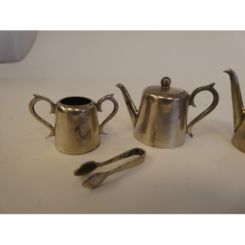 50 - Four items of silver dolls house teaware  comprising a teapot, hotwater pot, sugar basin with tongs ... 