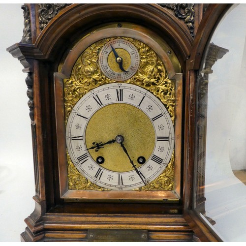 237 - A late 19thC burr walnut cased mantel clock with a domed top, brass finials, grilles and mounts; the... 