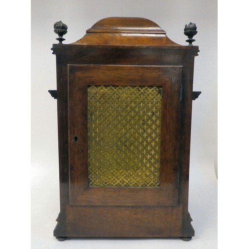 237 - A late 19thC burr walnut cased mantel clock with a domed top, brass finials, grilles and mounts; the... 