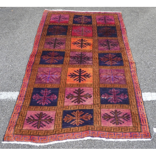 301 - An Iranian rug, decorated with twenty-one panels and snowflake design motifs, on a multi-coloured gr... 