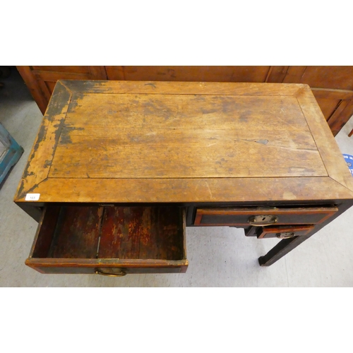 103 - A late 19th/early 20thC elm and fielded panelled kneehole work table, the mitred top over an arrange... 