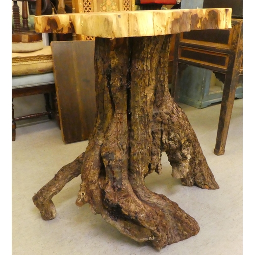 107 - A rough cut timber garden table, the crosscut, one piece top raised on a bark finished base  35