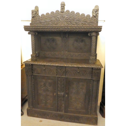 111 - A late 19thC stained and profusely carved, two part cupboard with a canopied superstructure, over a ... 