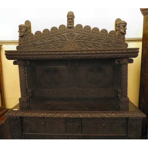 111 - A late 19thC stained and profusely carved, two part cupboard with a canopied superstructure, over a ... 