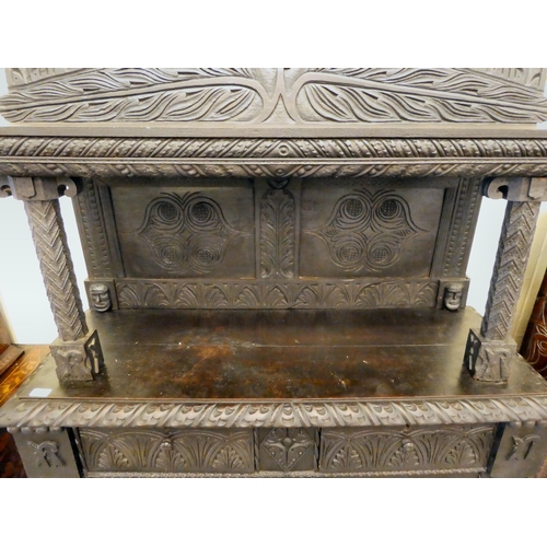 111 - A late 19thC stained and profusely carved, two part cupboard with a canopied superstructure, over a ... 