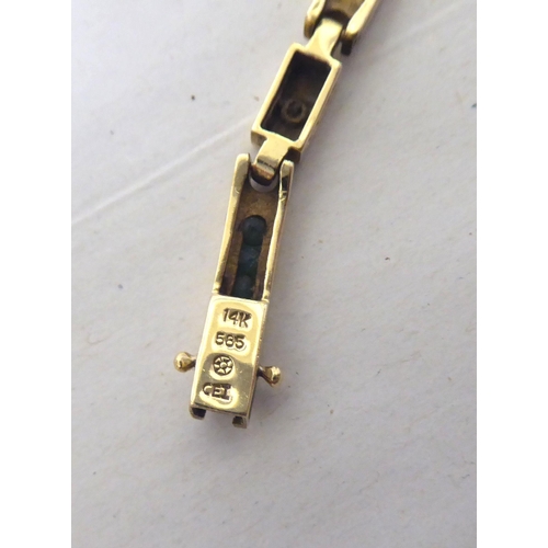 115 - A 14ct gold bracelet, set with diamonds and baguette cut emeralds