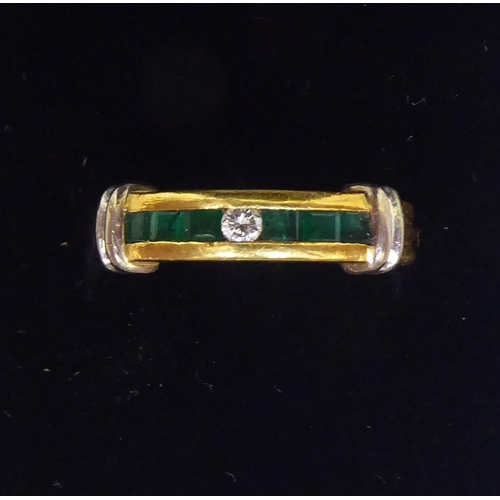 117 - An 18ct gold band design ring, set with a central diamond and baguette cut emeralds