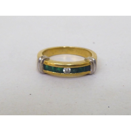 117 - An 18ct gold band design ring, set with a central diamond and baguette cut emeralds