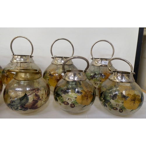 132 - A set of seven painted model glass T-light garden lanterns  largest 10