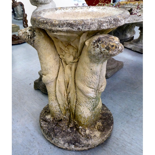 147 - A composition stone bird bath, the pedestal fashioned as three back-to-back otters  24