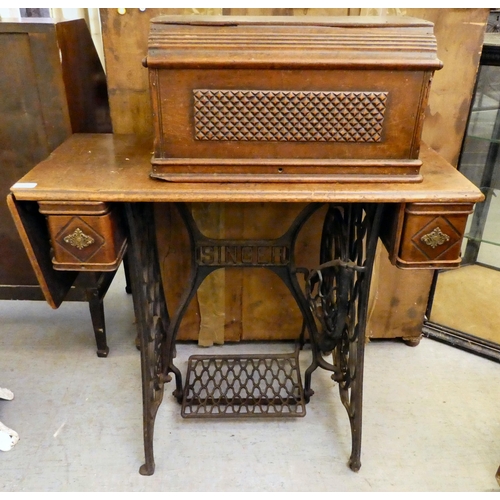 151 - A late Victorian Singer manual sewing machine, model.no.15128569, in a mahogany and cast iron treadl... 