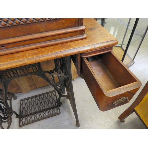 151 - A late Victorian Singer manual sewing machine, model.no.15128569, in a mahogany and cast iron treadl... 