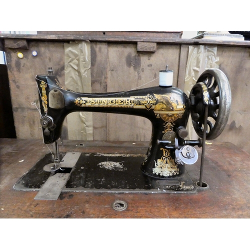 151 - A late Victorian Singer manual sewing machine, model.no.15128569, in a mahogany and cast iron treadl... 