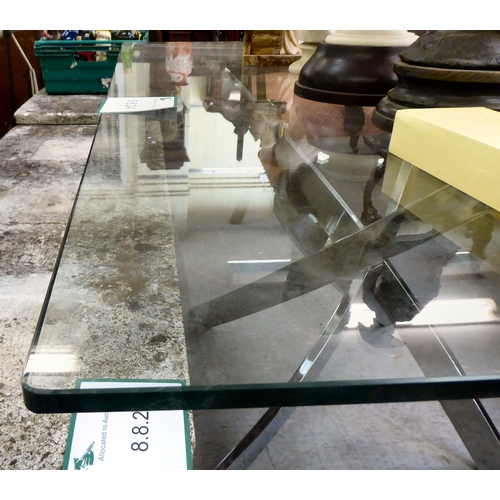 156 - A modern dining table, the glass top raised on a four spoke, chromium plated, crossover base  29