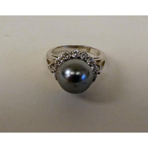 157 - A silver coloured metal ring, set with a river pearl and cubic zirconia 