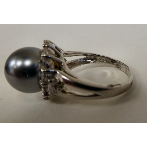 157 - A silver coloured metal ring, set with a river pearl and cubic zirconia 