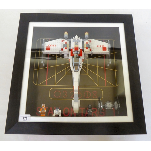 172 - A Lego Star Wars themed display, comprising three characters and an X-Wing fighter, in a deep set, g... 