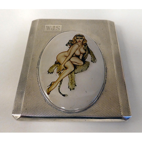 178 - A silver engine turned folding cigarette case, set with an enamelled plaque, depicting a glamour gir... 