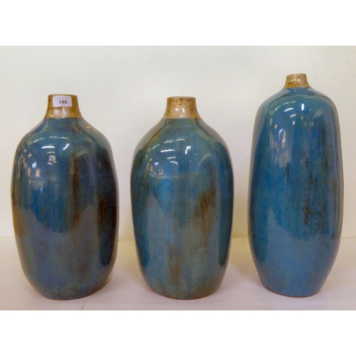 186 - A set of three streaky glazed two tone pottery vases  largest 17