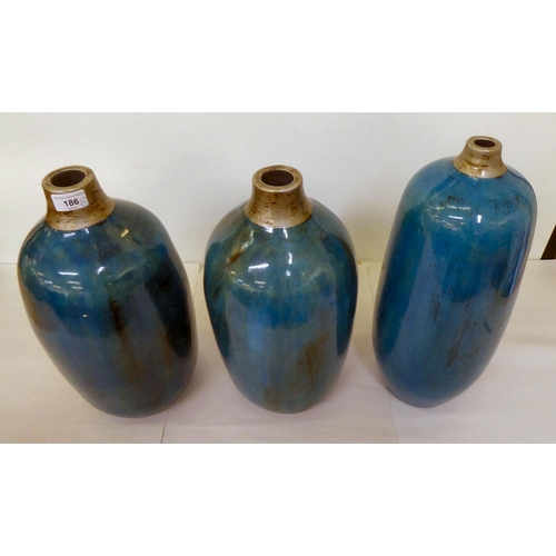 186 - A set of three streaky glazed two tone pottery vases  largest 17