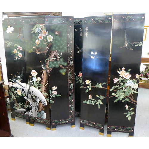 24 - A post World War II Oriental black lacquered and overpainted, six panel dressing room screen, decora... 