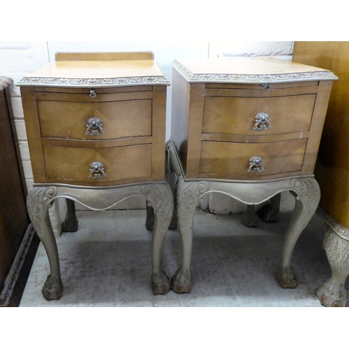 292 - A pair of mid 20thC crossbanded, bleached mahogany, two drawer bedside chests, raised on carved cabr... 