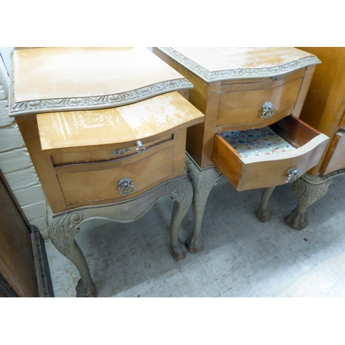 292 - A pair of mid 20thC crossbanded, bleached mahogany, two drawer bedside chests, raised on carved cabr... 