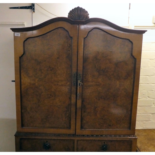 310 - A 20thC quarter veneered walnut two-part cabinet cocktail with a pair of shaped panelled doors, over... 