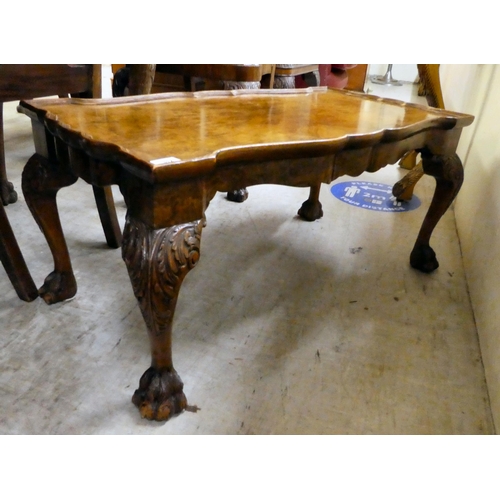 312 - A 20thC quarter veneered walnut, serpentine outlined coffee table, raised on carved cabriole legs an... 