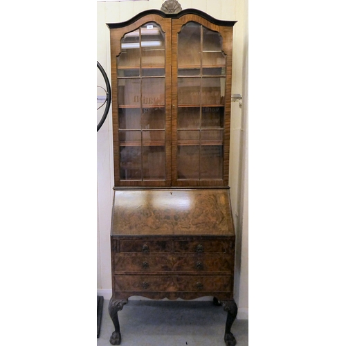 319 - A 20thC crossbanded, walnut veneered bureau bookcase, the upper section with a pair of glazed doors ... 