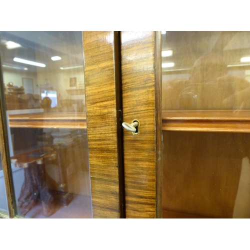 319 - A 20thC crossbanded, walnut veneered bureau bookcase, the upper section with a pair of glazed doors ... 