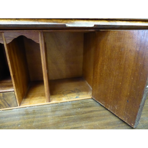 319 - A 20thC crossbanded, walnut veneered bureau bookcase, the upper section with a pair of glazed doors ... 