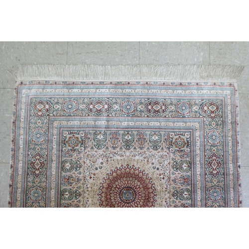 338 - An Iranian silk rug, woven in colours, around a central medallion  36