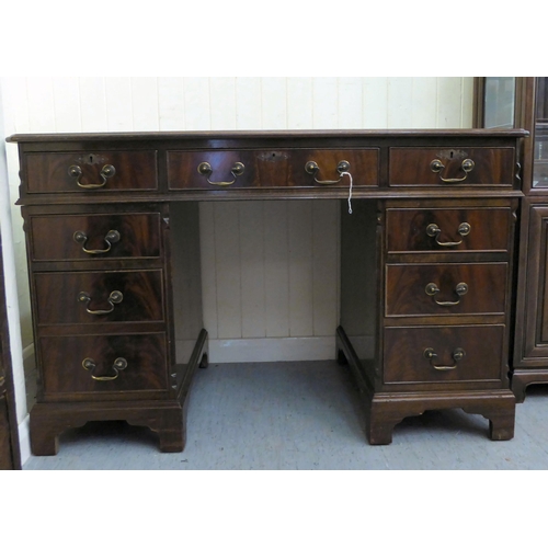 34 - A modern mahogany finished nine drawer, twin pedestal desk, the top set with a tooled scriber, raise... 