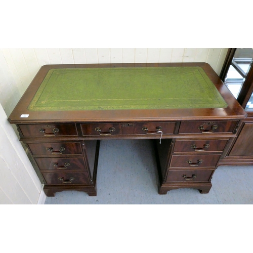 34 - A modern mahogany finished nine drawer, twin pedestal desk, the top set with a tooled scriber, raise... 