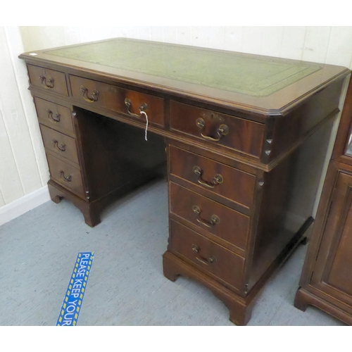 34 - A modern mahogany finished nine drawer, twin pedestal desk, the top set with a tooled scriber, raise... 