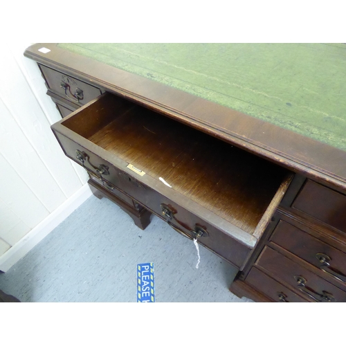 34 - A modern mahogany finished nine drawer, twin pedestal desk, the top set with a tooled scriber, raise... 