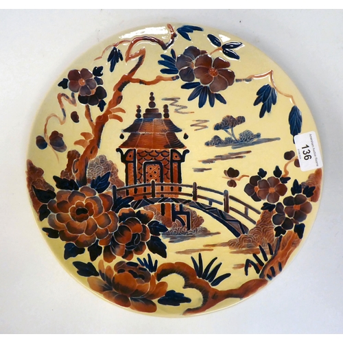 342 - A Crown Ducal Charlotte Rhead china wall plate, decorated in Oriental taste with a garden bridge and... 