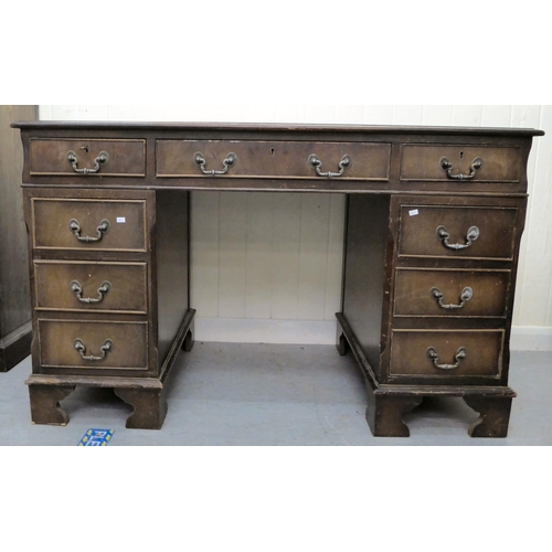 35 - A modern mahogany finished nine drawer, twin pedestal desk, the top set with a tooled scriber, raise... 