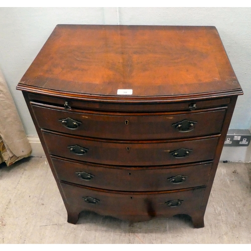 38 - A modern mahogany bowfront dressing chest with a brushing slide and four long drawers, raised on bra... 