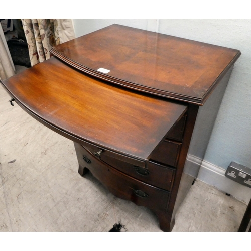 38 - A modern mahogany bowfront dressing chest with a brushing slide and four long drawers, raised on bra... 