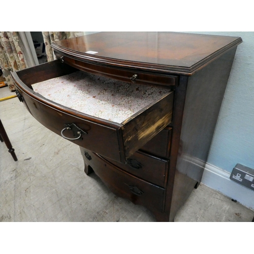 38 - A modern mahogany bowfront dressing chest with a brushing slide and four long drawers, raised on bra... 