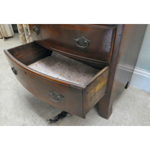 38 - A modern mahogany bowfront dressing chest with a brushing slide and four long drawers, raised on bra... 