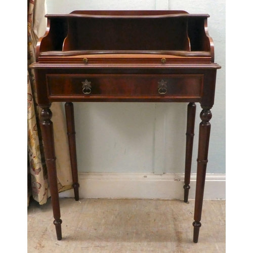 43 - A modern lady's mahogany finished writing desk with a single drawer, raised on turned legs  37