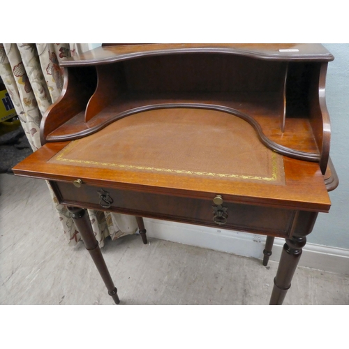 43 - A modern lady's mahogany finished writing desk with a single drawer, raised on turned legs  37