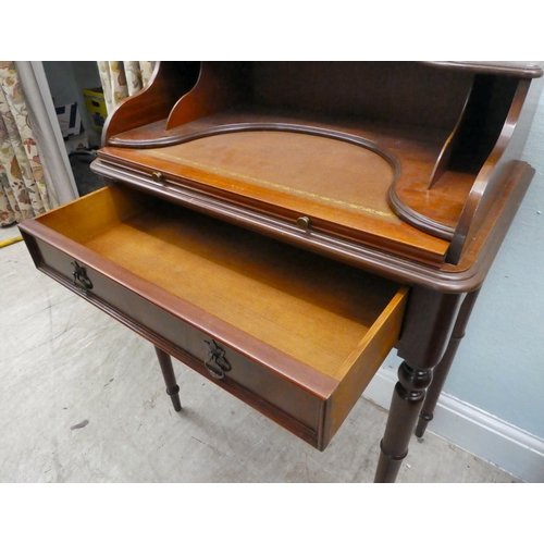 43 - A modern lady's mahogany finished writing desk with a single drawer, raised on turned legs  37