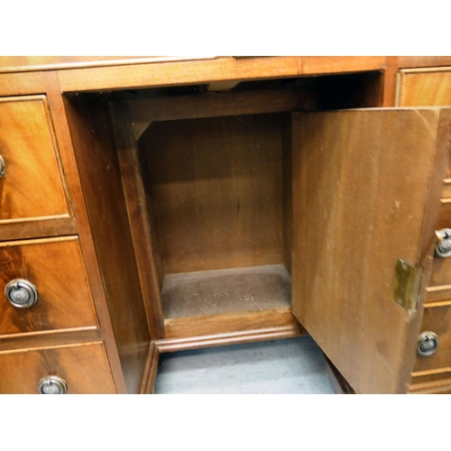 45 - A modern mahogany kneehole desk with a central cupboard and eight drawers, raised on bracket feet&nb... 