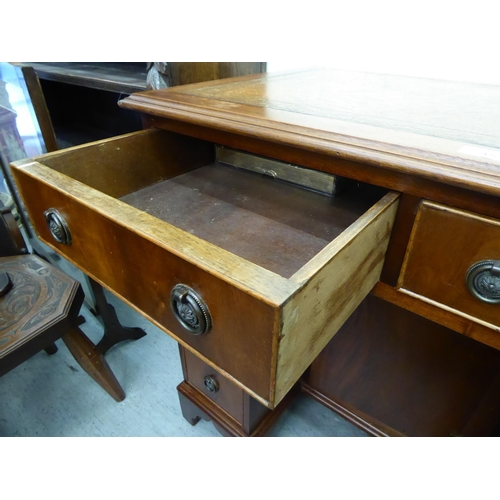 45 - A modern mahogany kneehole desk with a central cupboard and eight drawers, raised on bracket feet&nb... 