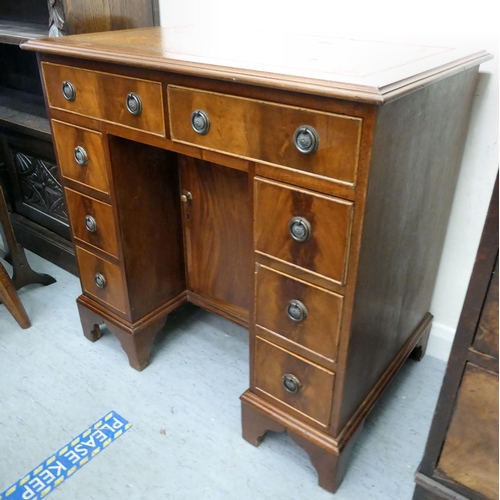 45 - A modern mahogany kneehole desk with a central cupboard and eight drawers, raised on bracket feet&nb... 