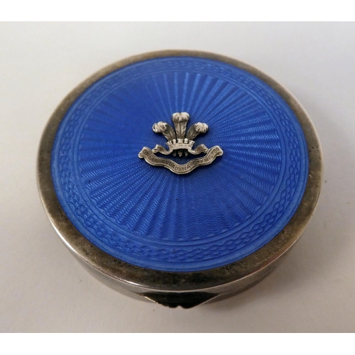 6 - A silver circular powder compact with a hinged, engine turned blue enamel lid and an applied emblem ... 